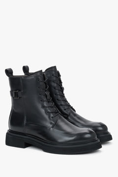 Diagonale Ansicht des Paares schwarzer Leder-Stiefeletten, die die robuste Silhouette und die flache EVA-Sohle zeigt