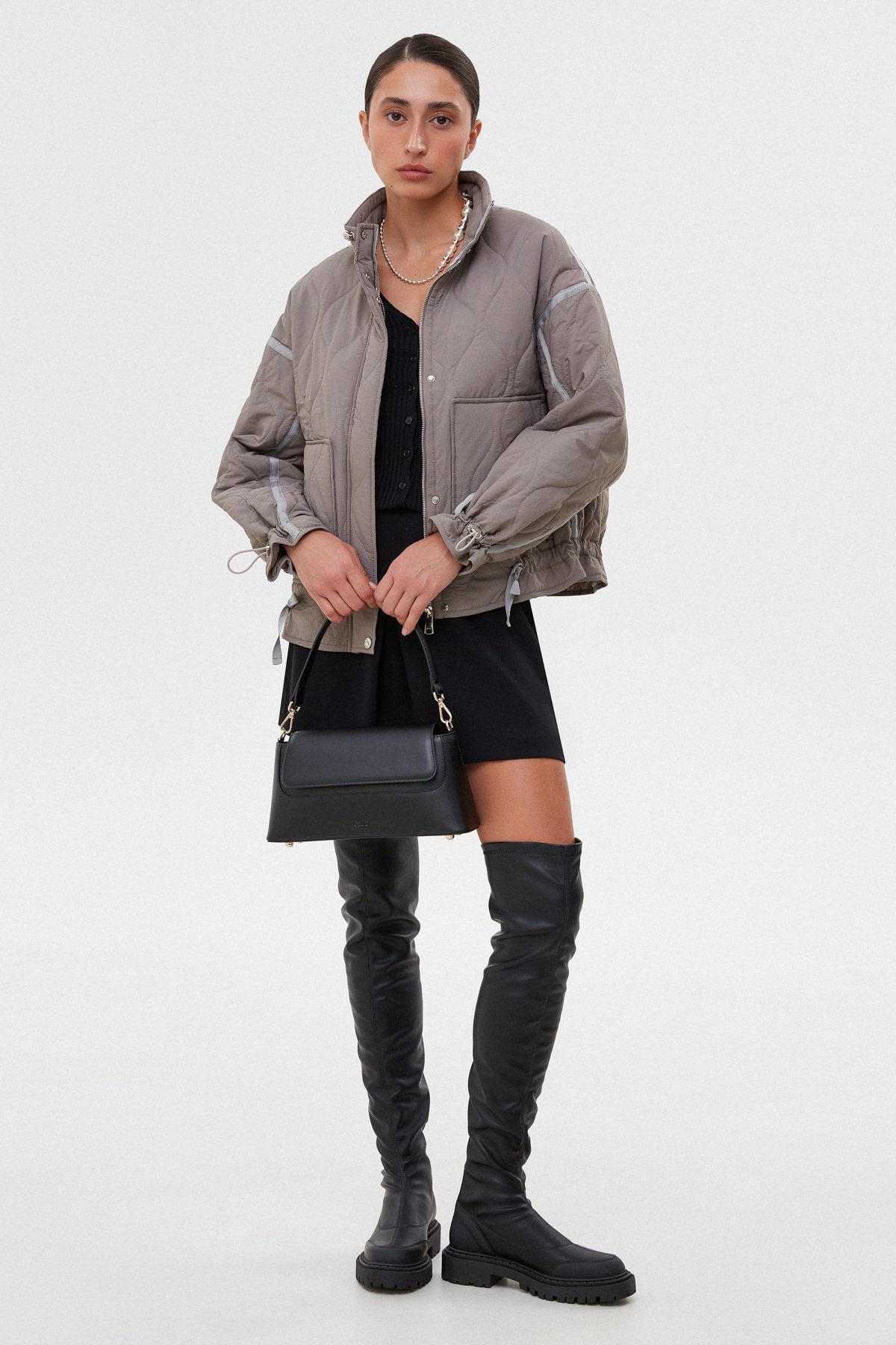 Model präsentiert die langen schwarzen Lederstiefel mit elastischem Schaft
