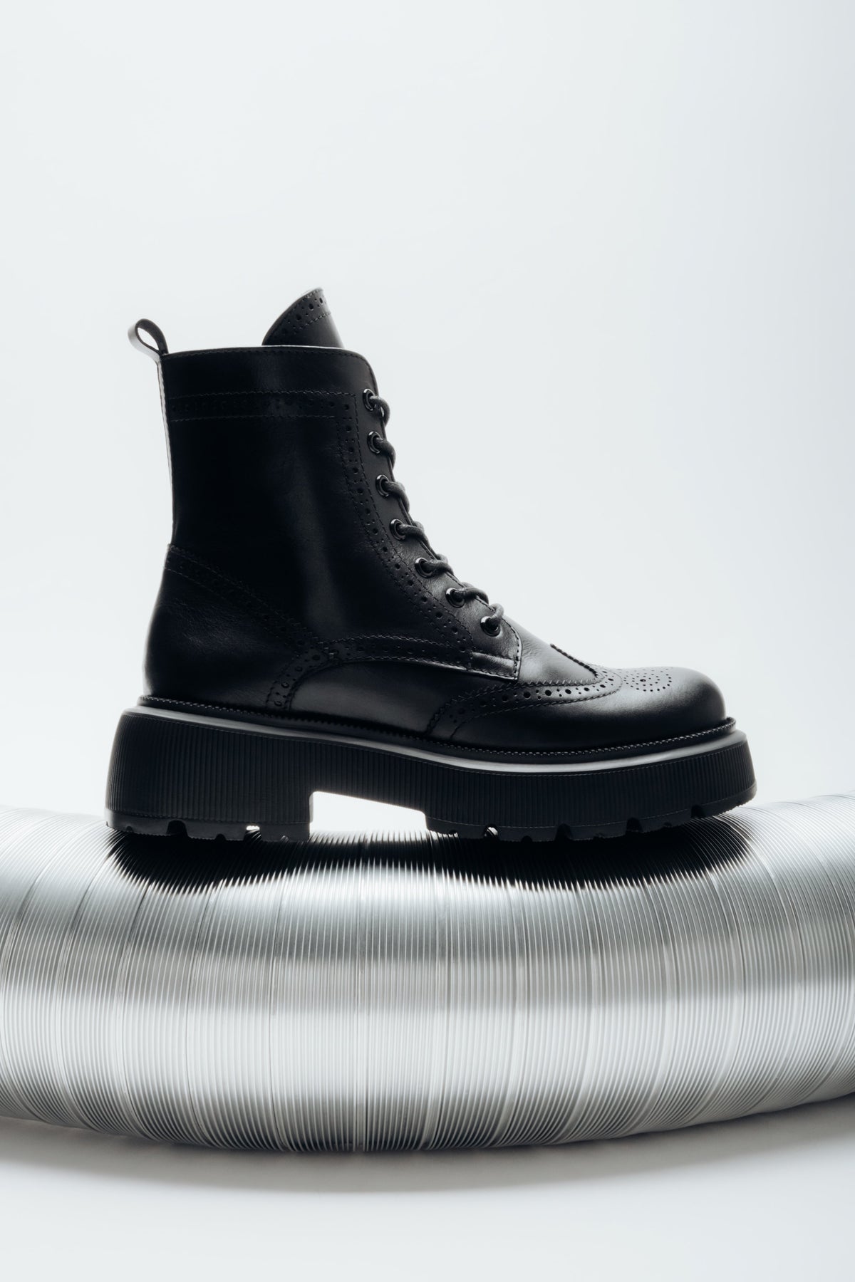 Reines Seitenprofil der rechten schwarzen Stiefelette mit sichtbarem Reißverschluss und Schnürung