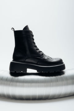 Reines Seitenprofil der rechten schwarzen Stiefelette mit sichtbarem Reißverschluss und Schnürung