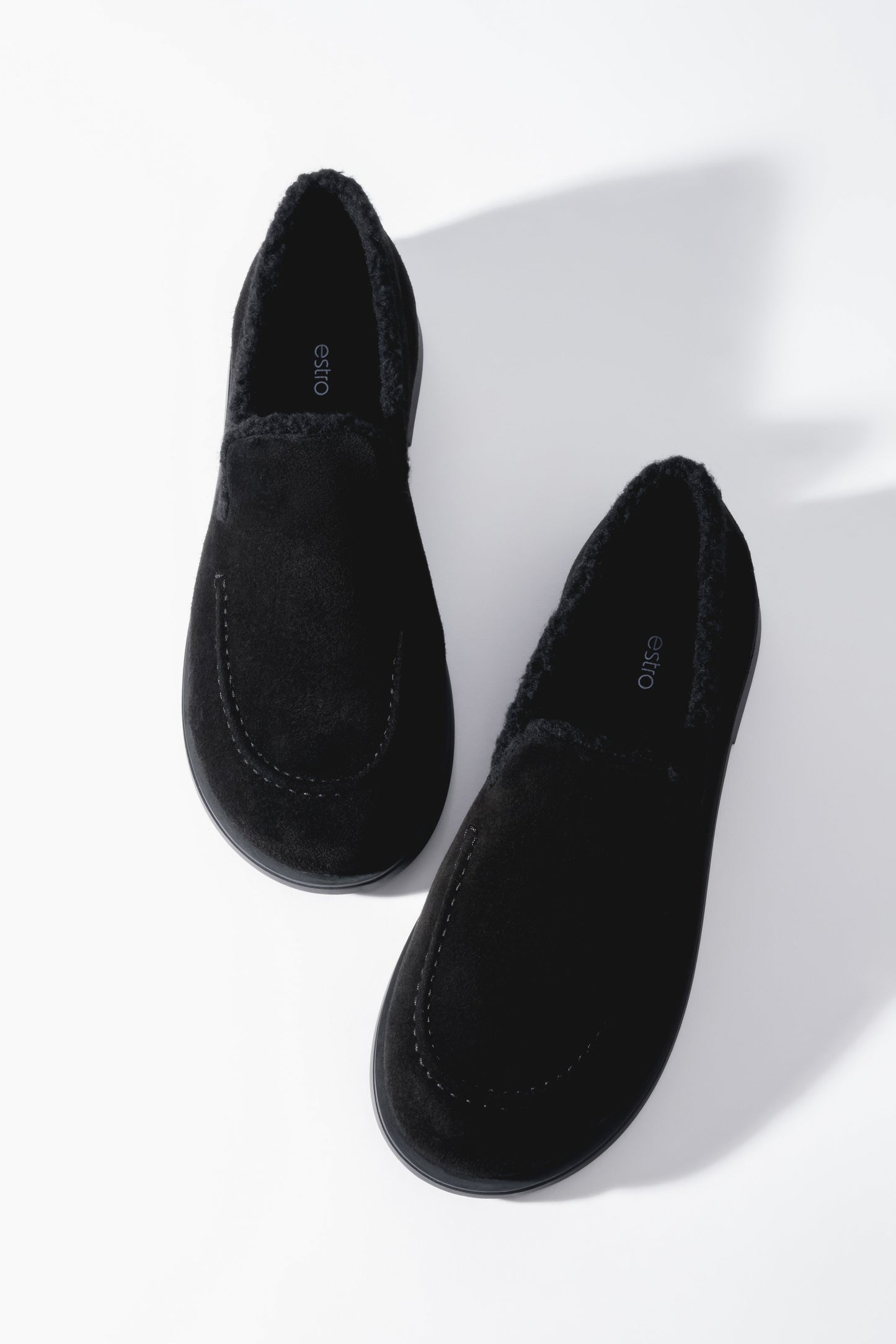 Ästhetische Aufnahme der schwarzen, gefütterten Damen-Loafers aus der Vogelperspektive