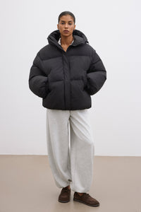 Frontalansicht der schwarzen Damen-Oversize-Jacke mit Kapuze, präsentiert im modernen urbanen Styling 