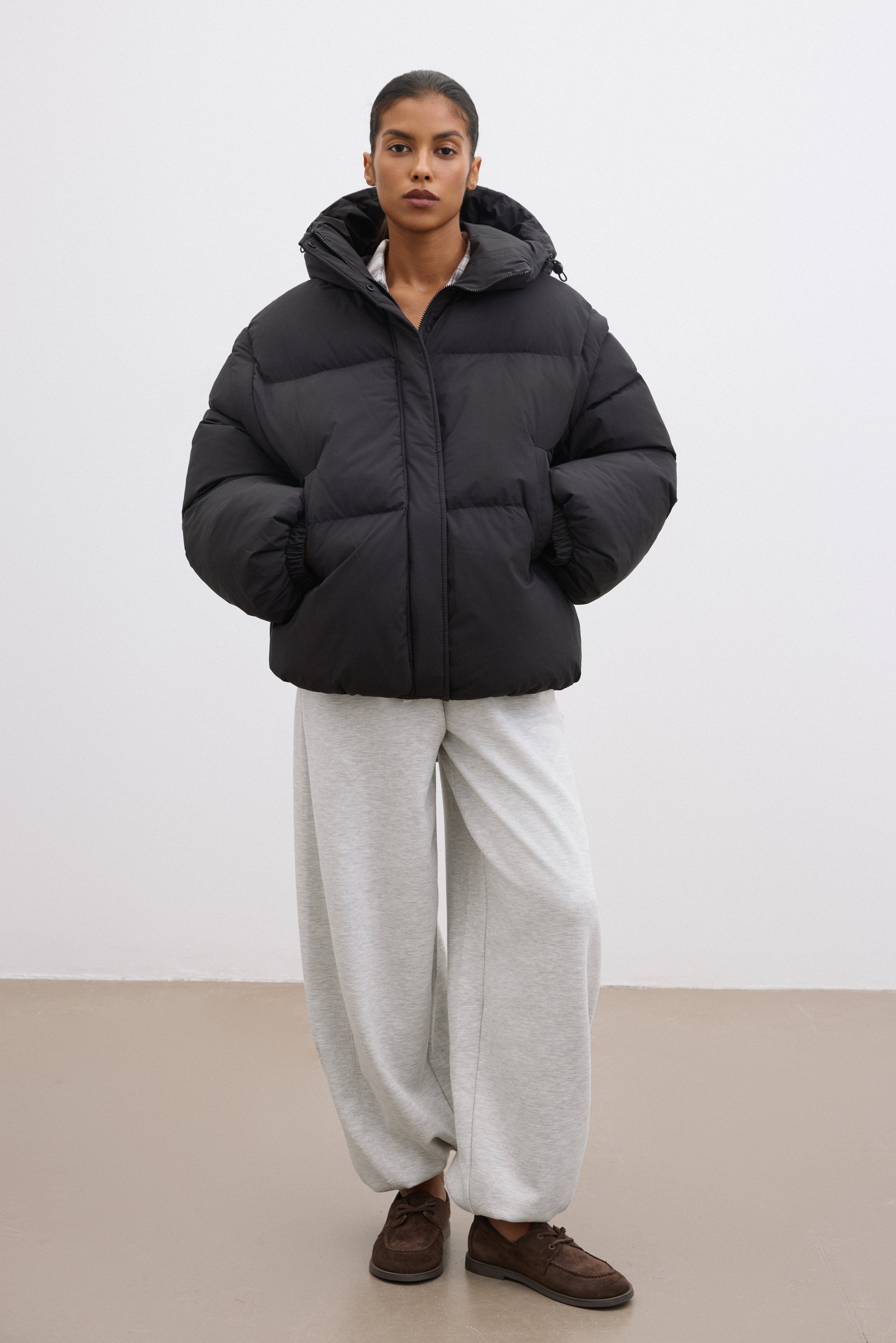 Frontalansicht der schwarzen Damen-Oversize-Jacke mit Kapuze, präsentiert im modernen urbanen Styling 