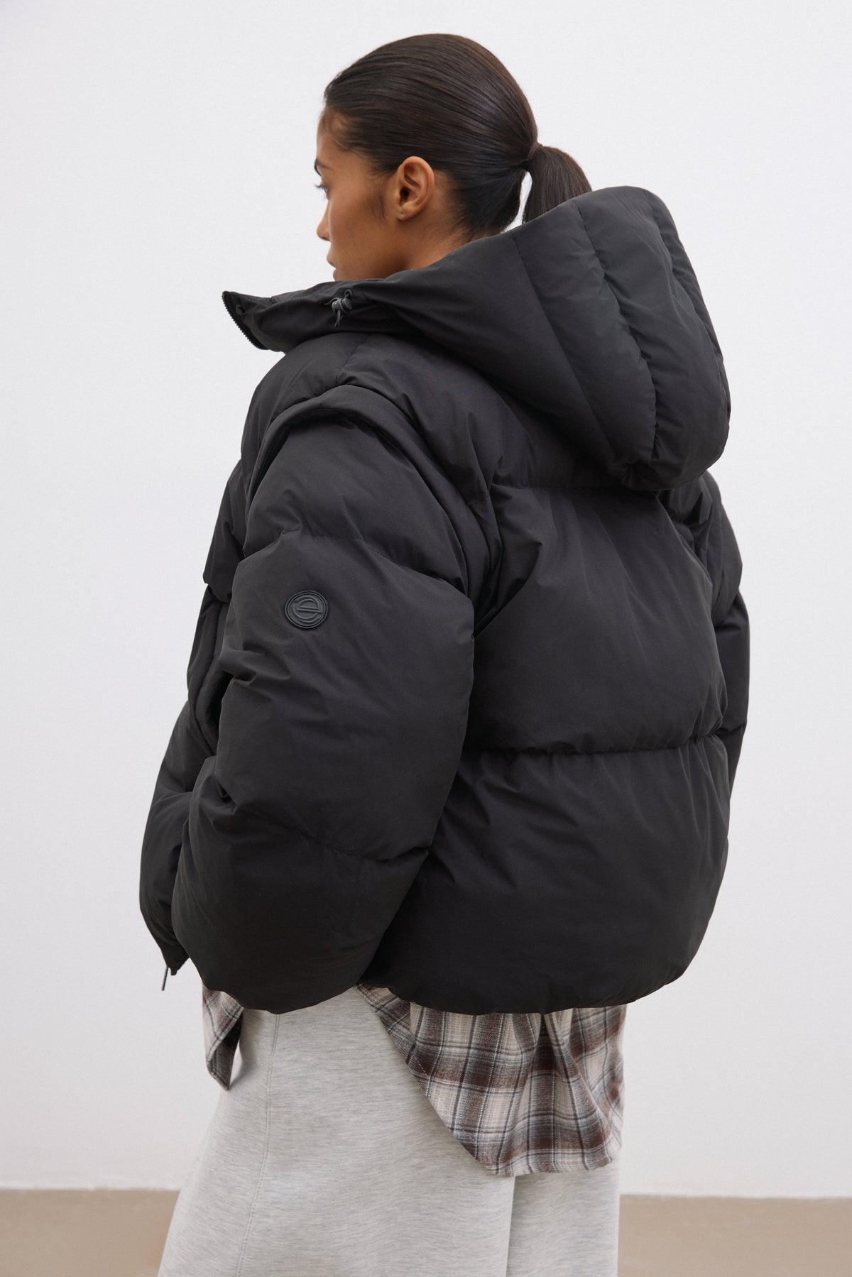 Rückansicht der voluminösen schwarzen Winterjacke mit Steppung, die die legere Passform zeigt 
