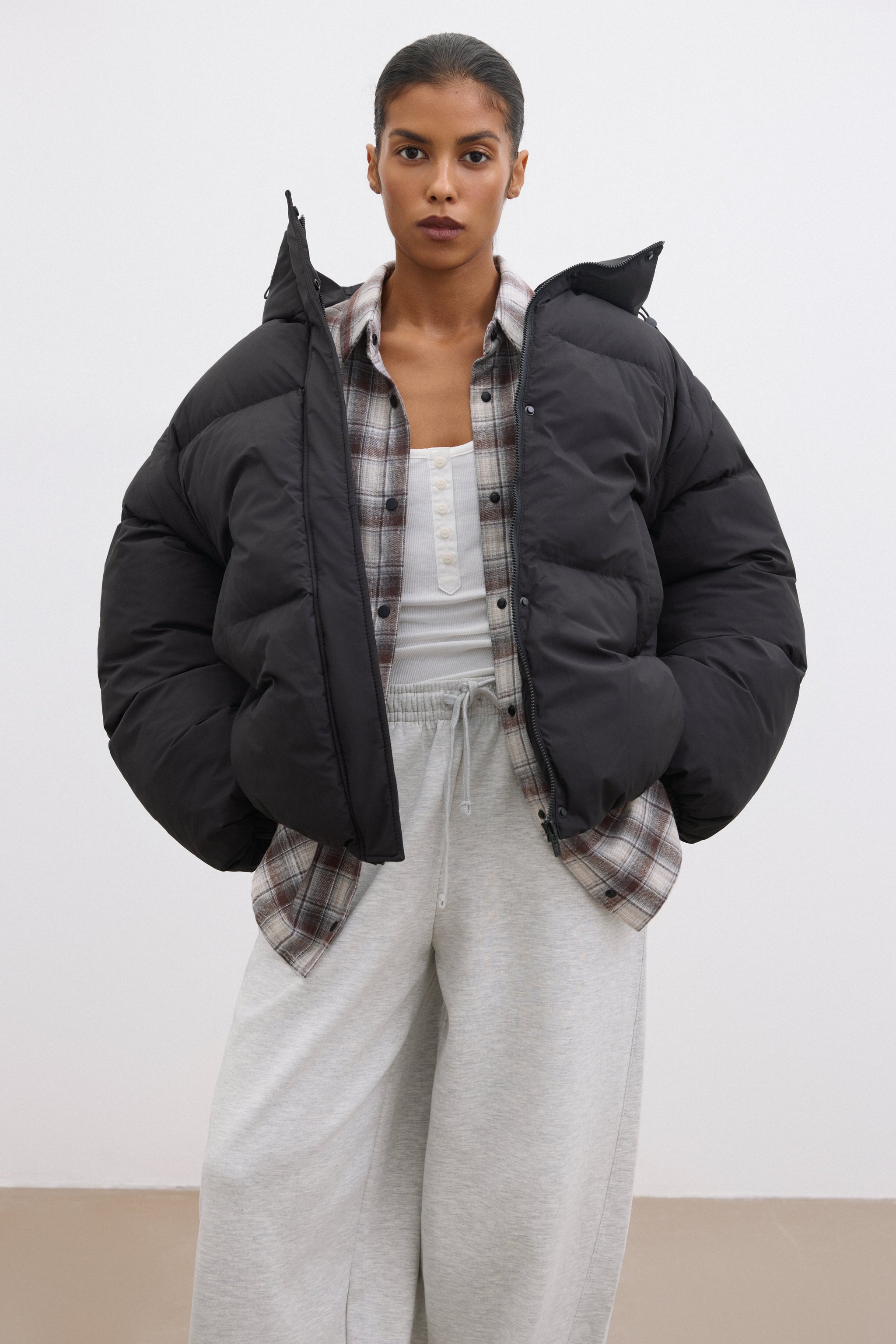 Model präsentiert die schwarze Oversize-Weste (abgenommene Ärmel) kombiniert mit Freizeitkleidung 