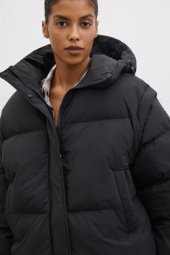 Porträt des Models in der schwarzen Oversize-Jacke mit Kapuze und hohem Stehkragen
