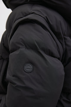 Detailaufnahme des Ärmels der schwarzen Pufferjacke, die das matte Obermaterial und die Steppung hervorhebt