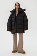 Frontale Ansicht der schwarzen Oversize-Pufferjacke an der Model
