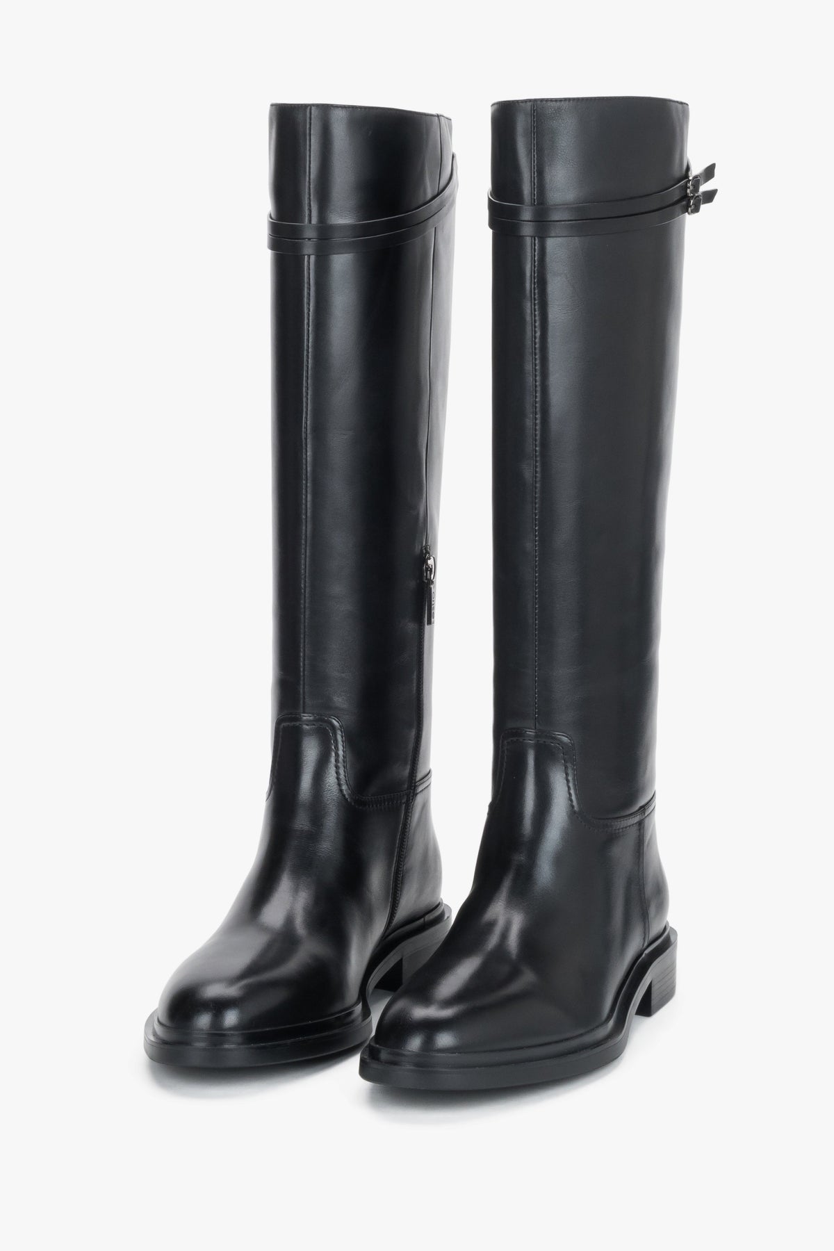 Frontale leicht gedrehte Ansicht des Paares schwarzer Reitstiefel, die die runde Zehenpartie und den glatten Schaft betont
