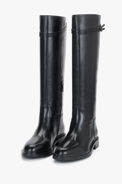 Frontale leicht gedrehte Ansicht des Paares schwarzer Reitstiefel, die die runde Zehenpartie und den glatten Schaft betont