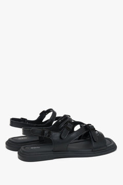 Andere schräge Ansicht der bequemen schwarzen Sandalen mit verstellbarer Schnalle.