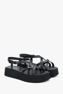 Schrägansicht des Paares schwarzer Plateau-Sandalen aus Leder mit überkreuzten Riemen