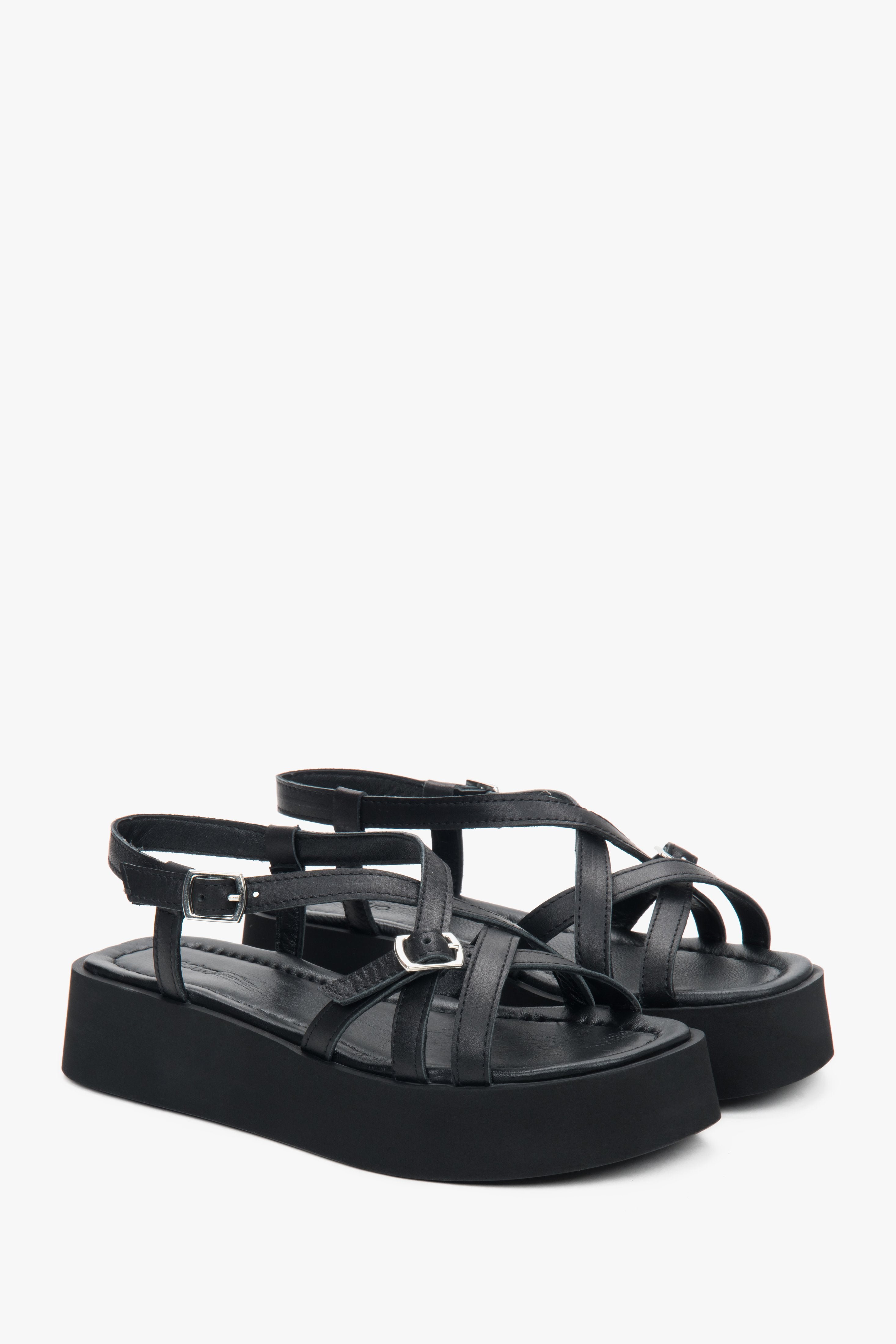 Schrägansicht des Paares schwarzer Plateau-Sandalen aus Leder mit überkreuzten Riemen