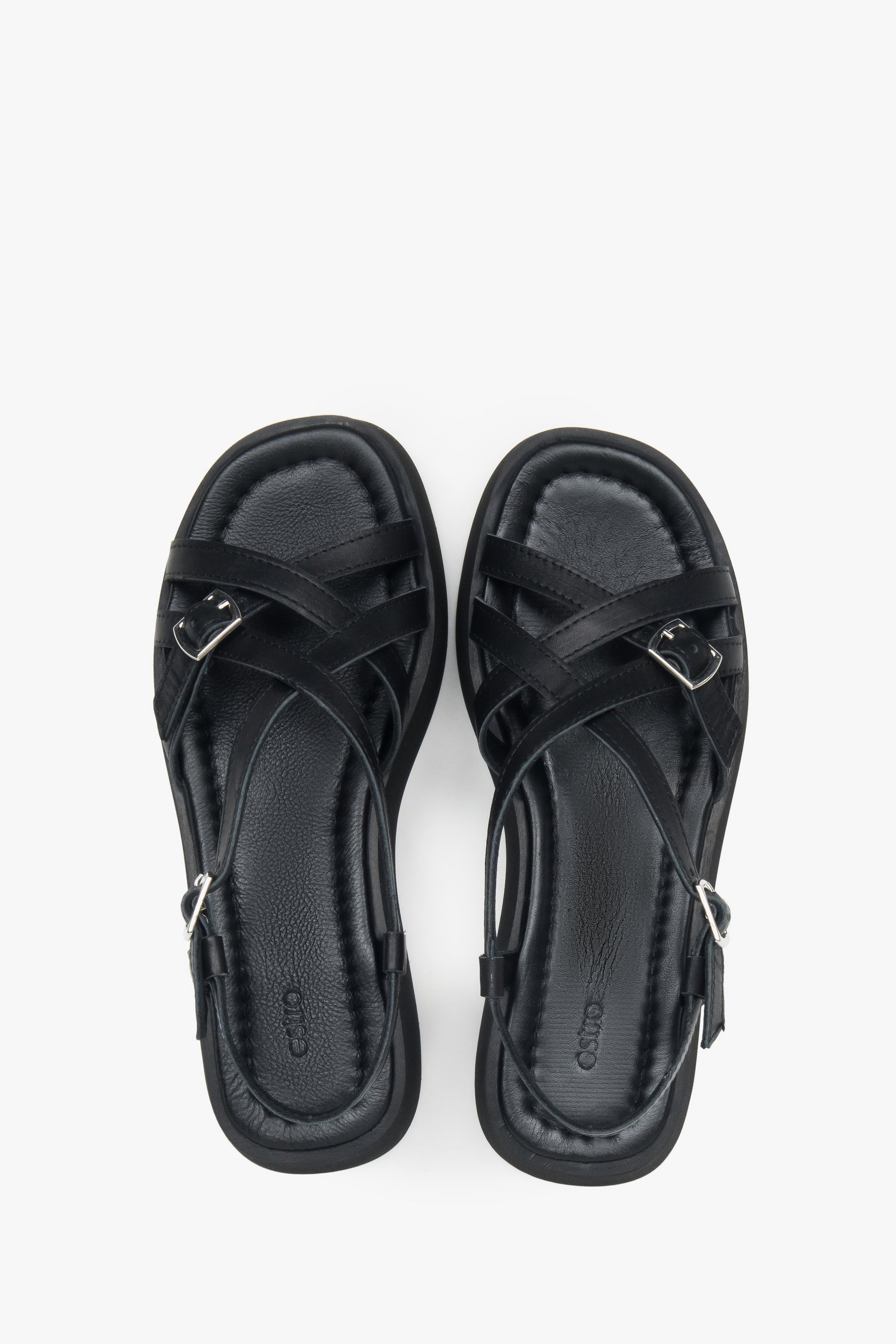 Draufsicht auf das Echtleder-Fußbett und die überkreuzten Riemen der schwarzen Sandalen
