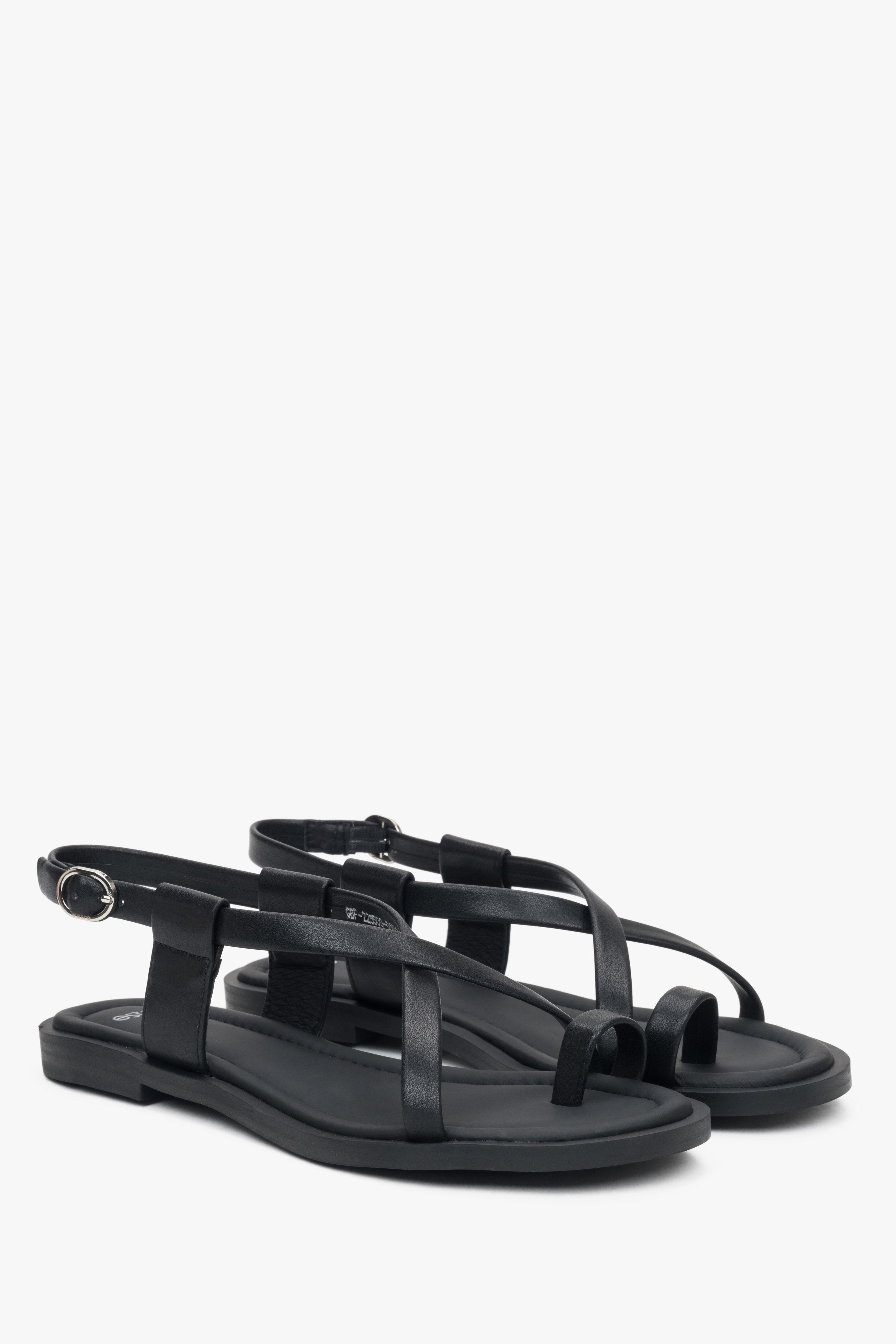 Schräge Seitenansicht der schwarzen Damen-Sandalen mit Zehenschlaufe und silbernen Details.