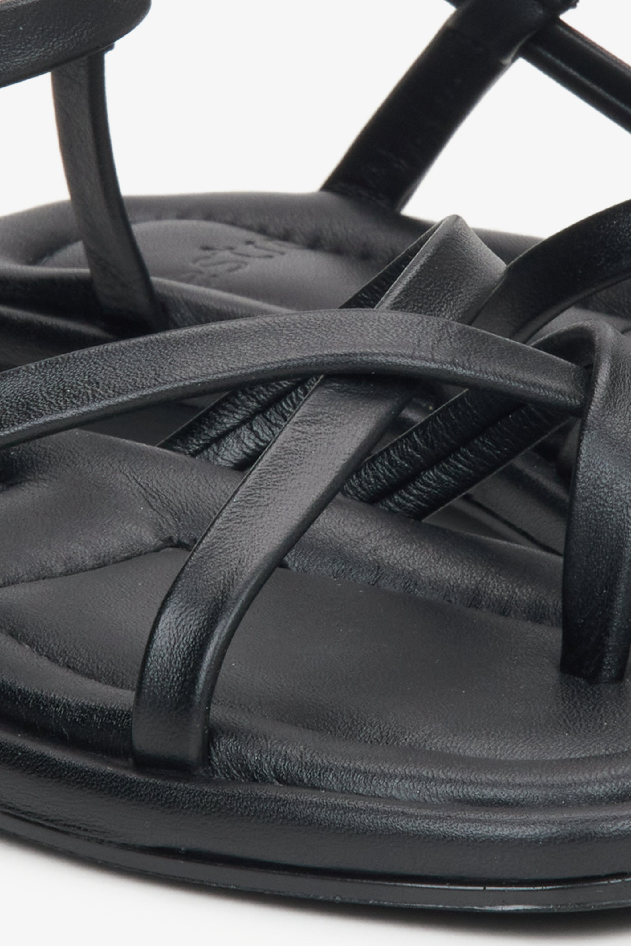 Detailaufnahme schwarzer Damen-Sandalen aus Leder mit gekreuzten Riemen