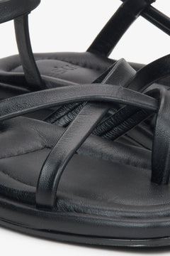 Detailaufnahme schwarzer Damen-Sandalen aus Leder mit gekreuzten Riemen