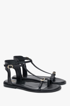 Schwarze Damen-Sandalen aus Leder in schräger Vorderansicht mit goldfarbenen Schnallen