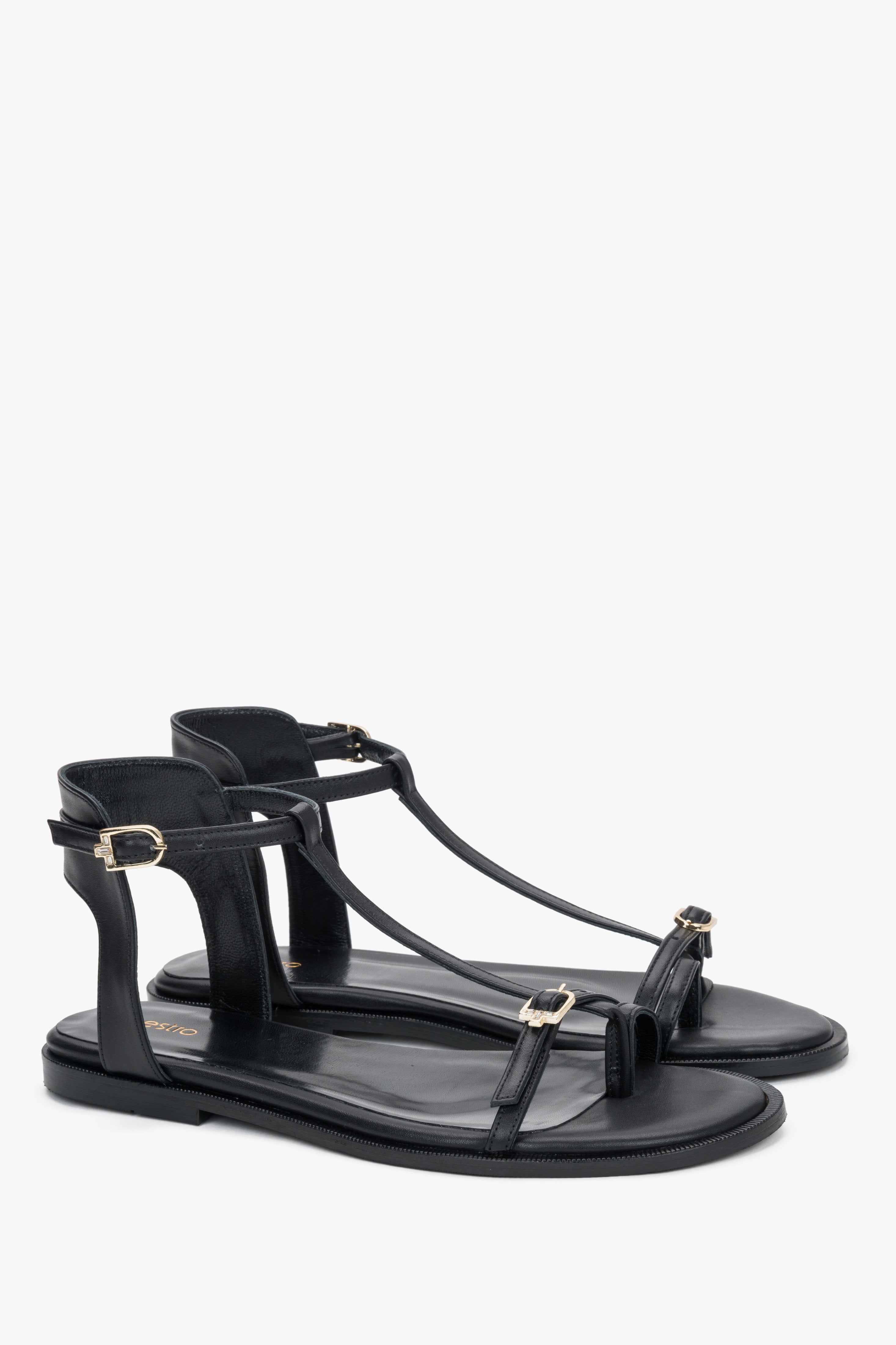 Schwarze Damen-Sandalen aus Leder in schräger Vorderansicht mit goldfarbenen Schnallen