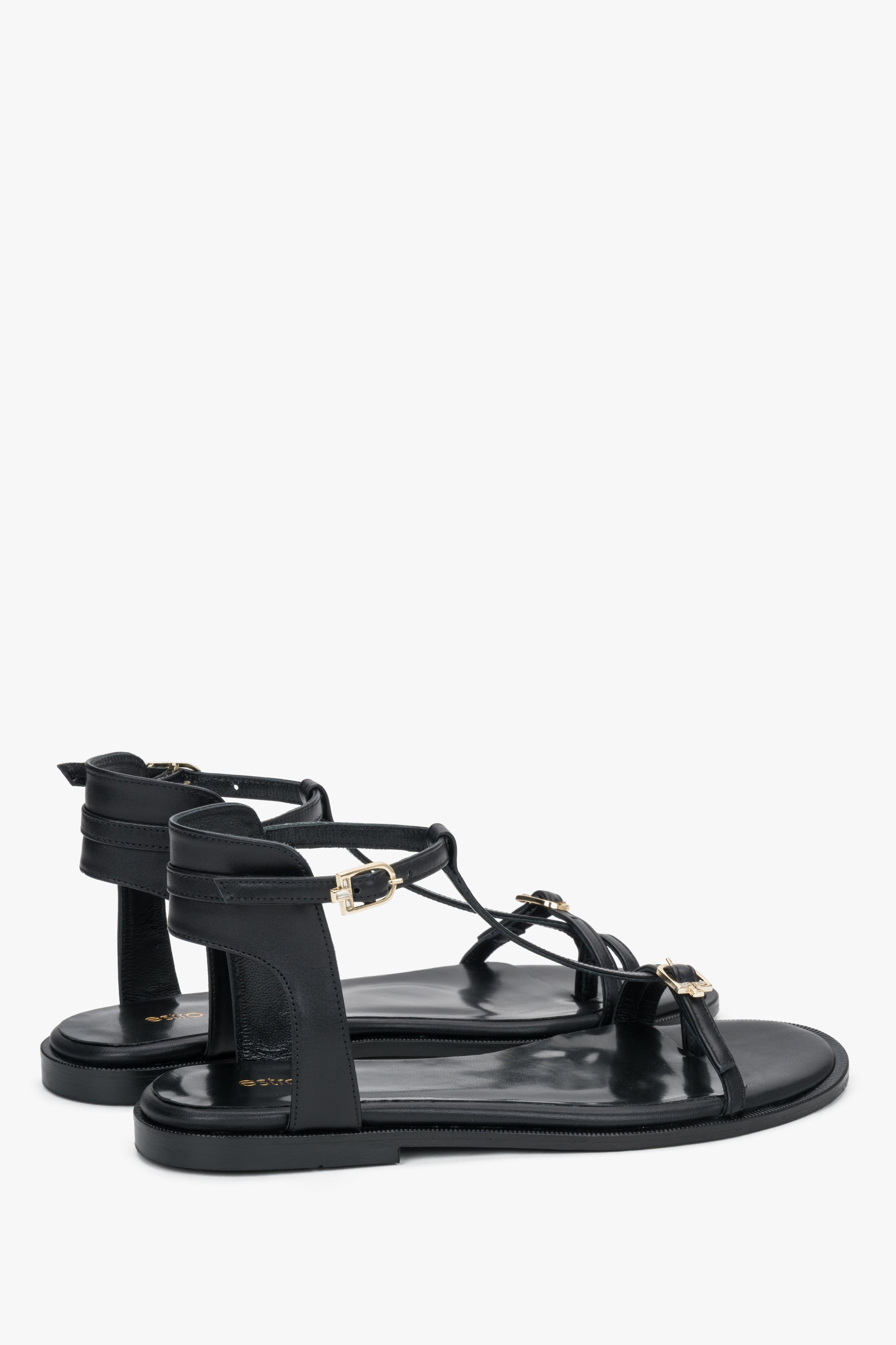 Schwarze Damen-Sandalen aus Leder in schräger Seitenansicht mit goldfarbenen Schnallen