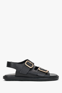 Seitenansicht der schwarzen Damen-Sandalen aus Leder mit goldenen Schnallen