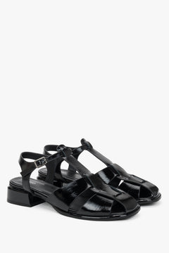 Paar schwarze Lackleder-Sandalen mit T-Strap von vorne