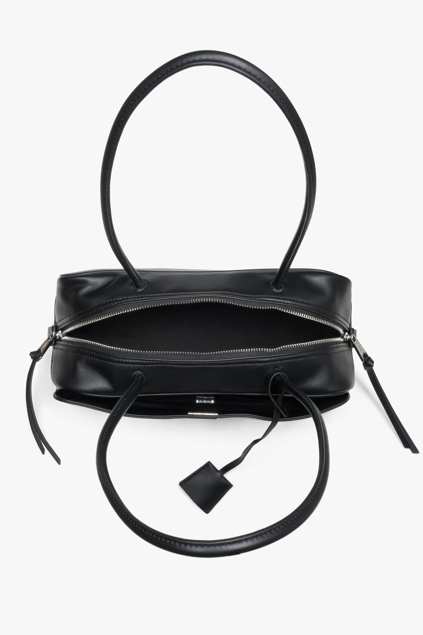 Detailansicht der Tasche von oben mit Fokus auf die zwei Reißverschlussfächer und Henkel.