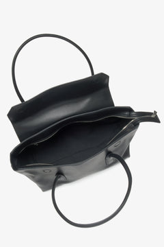 Blick von oben in das geöffnete, geräumige Hauptfach der schwarzen Handtasche