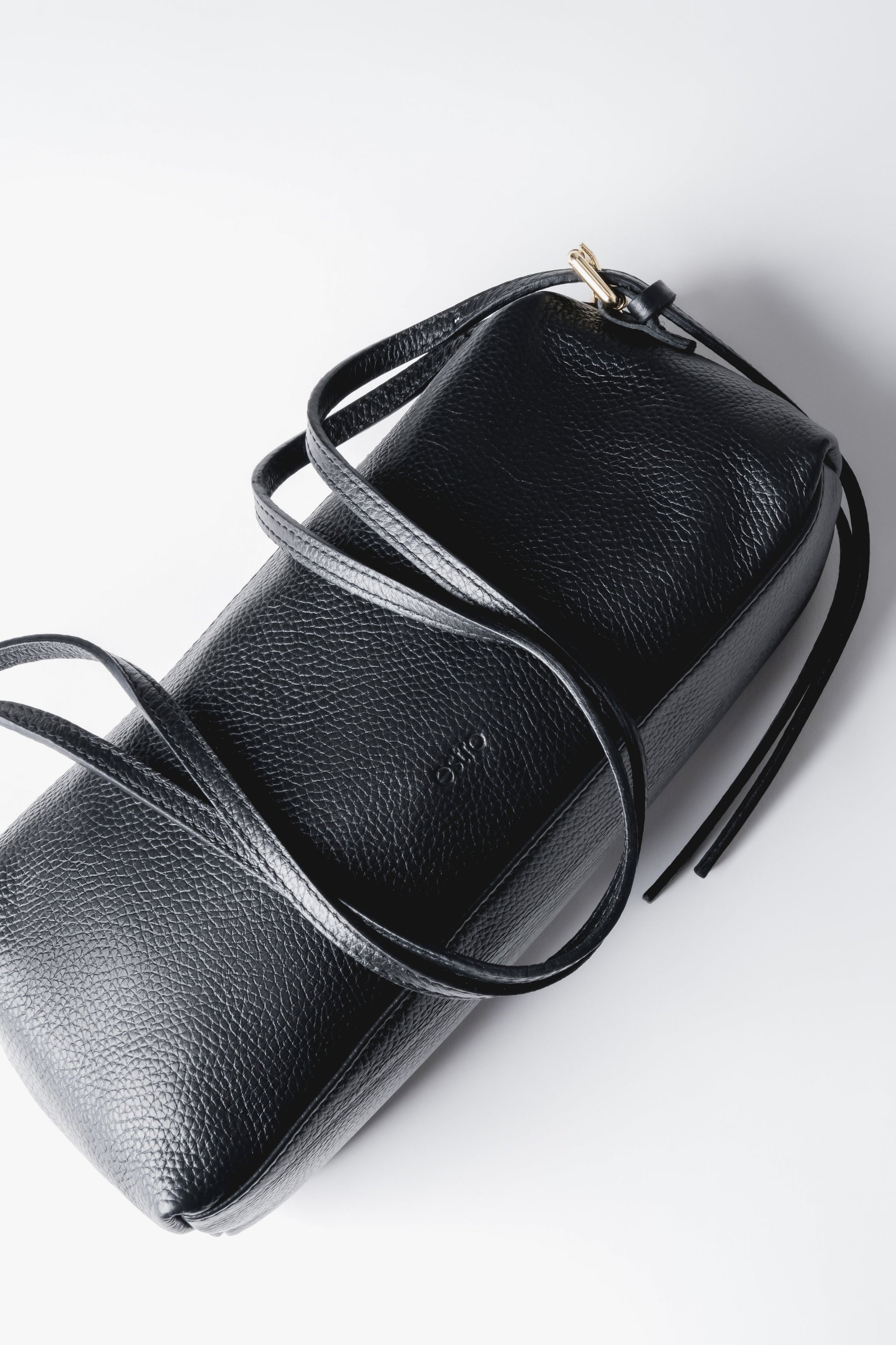 Blick von oben auf die Tasche, der die Tiefe von 8,5 cm, die genarbte Ledertextur und den Reißverschluss präsentiert 
