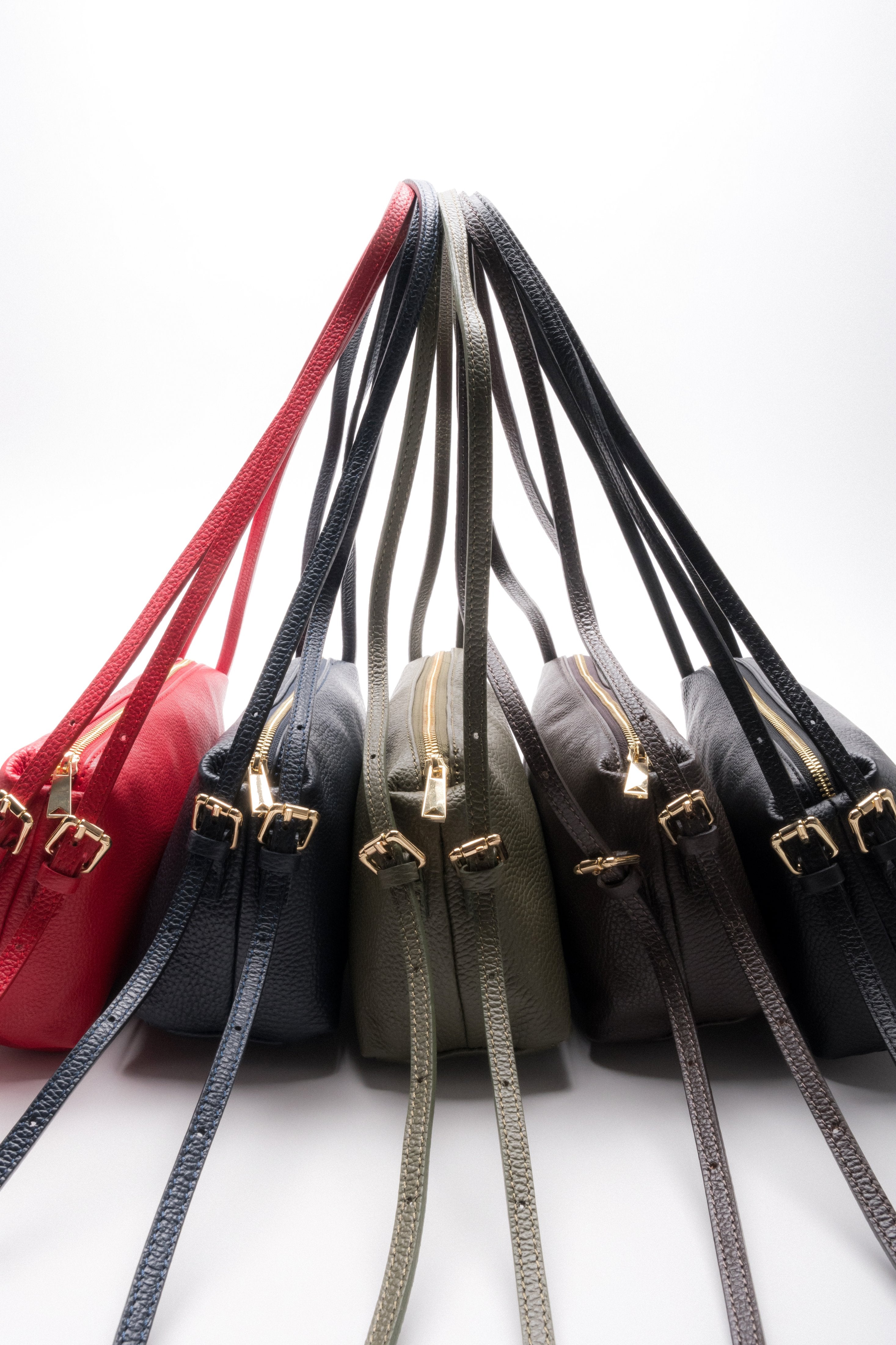 Kreative, fächerförmige Anordnung der länglichen Ledertaschen aus der Kollektion in verschiedenen Farbvarianten 