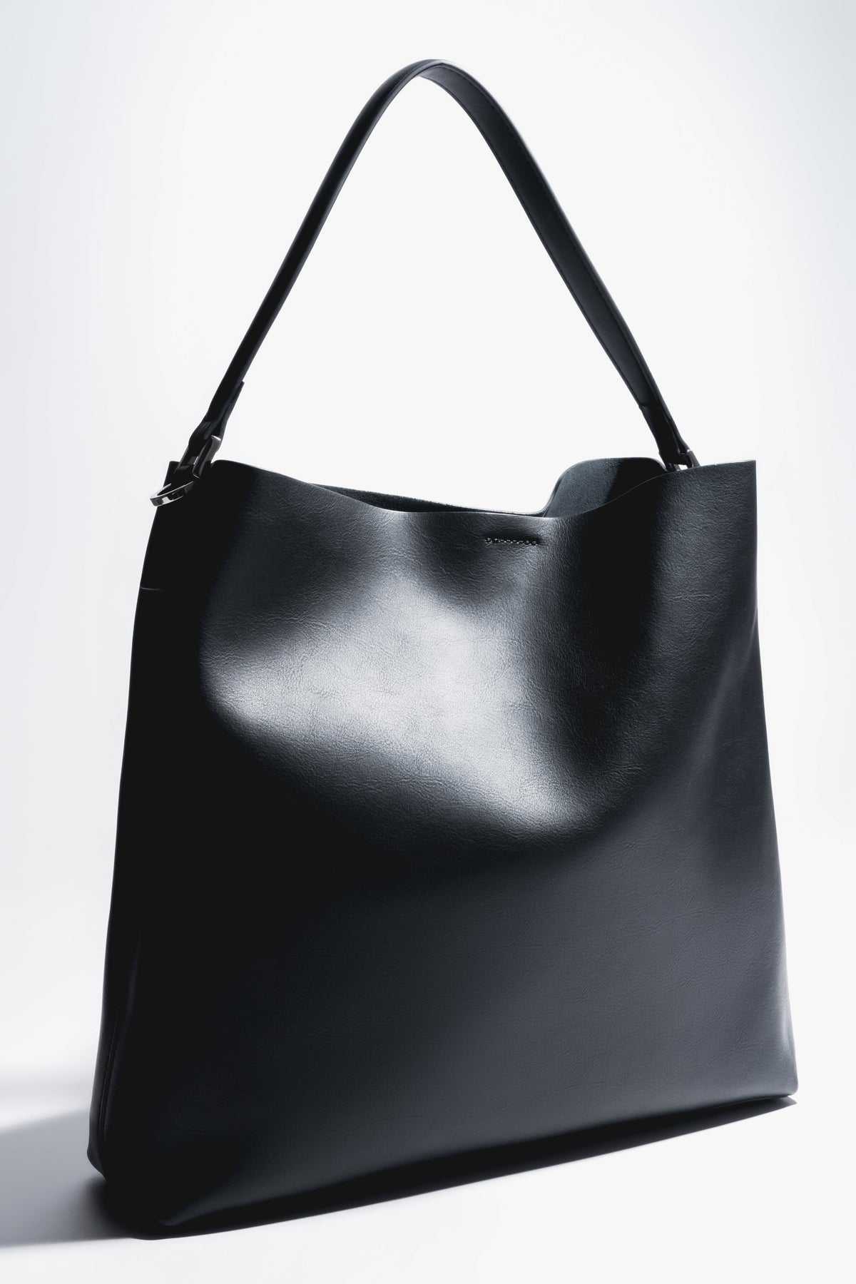 Schräge Frontalansicht der schwarzen Damen-Shopper-Tasche aus Glattleder mit kurzem Henkel