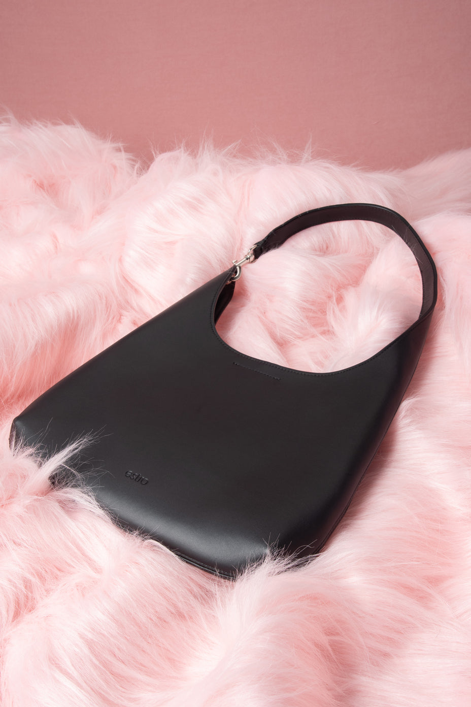 Seitenprofil der Damen Schultertasche aus schwarzem Leder vor hellem Hintergrund.