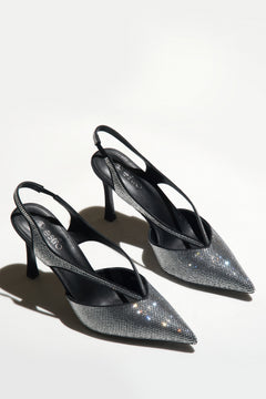 Zwei schwarze Slingback-Pumps mit funkelnden Kristallen auf hellem Hintergrund