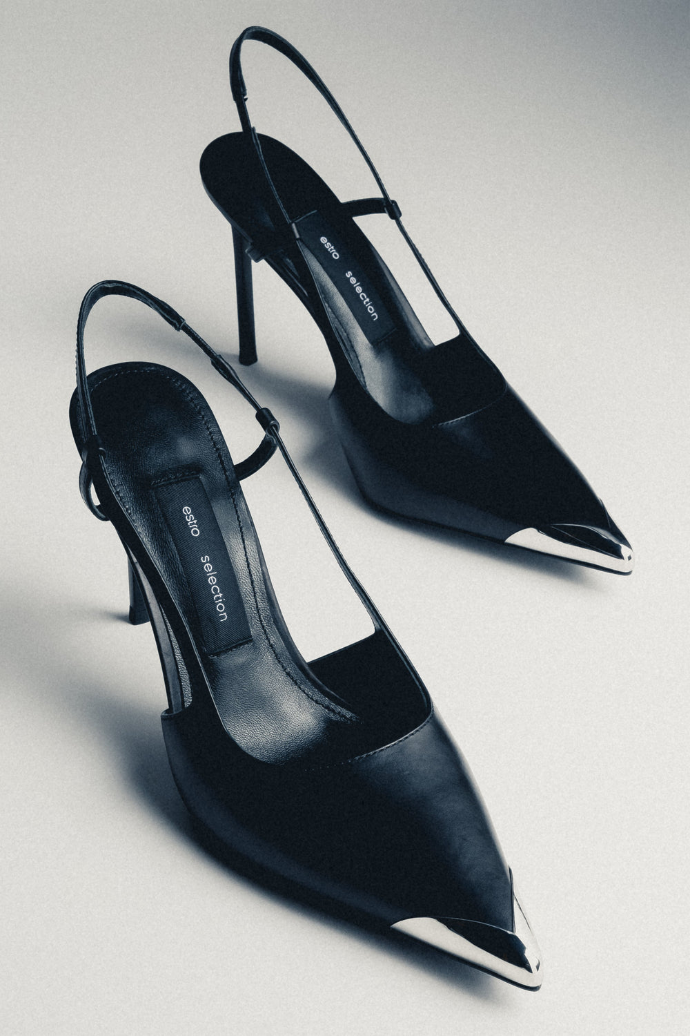 Schwarze Damen-Slingpumps aus Echtleder in schräger Vorderansicht mit silberfarbener Spitze