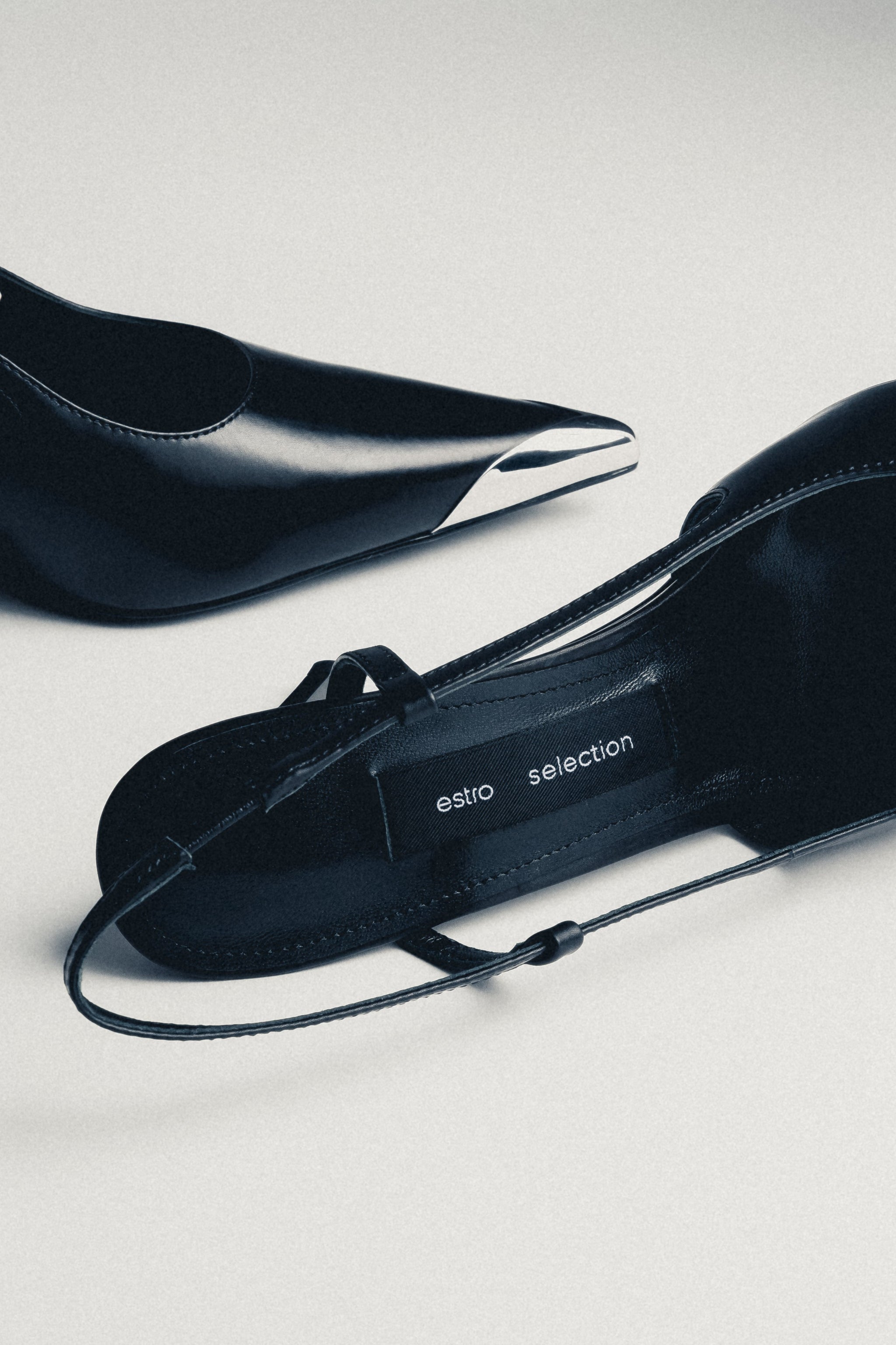 Detailansicht schwarzer Damen-Slingpumps mit silberfarbener Spitze