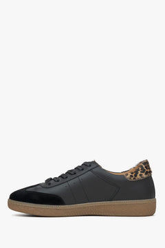 Flache Seitenansicht des schwarzen Sneakers auf hellem Hintergrund