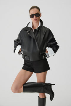 Model im urbanen Look posiert mit der Lederjacke und den schwarzen Stiefeln