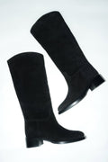 Künstlerische Draufsicht des schwarzen Veloursstiefel-Paares auf hellem Untergrund 