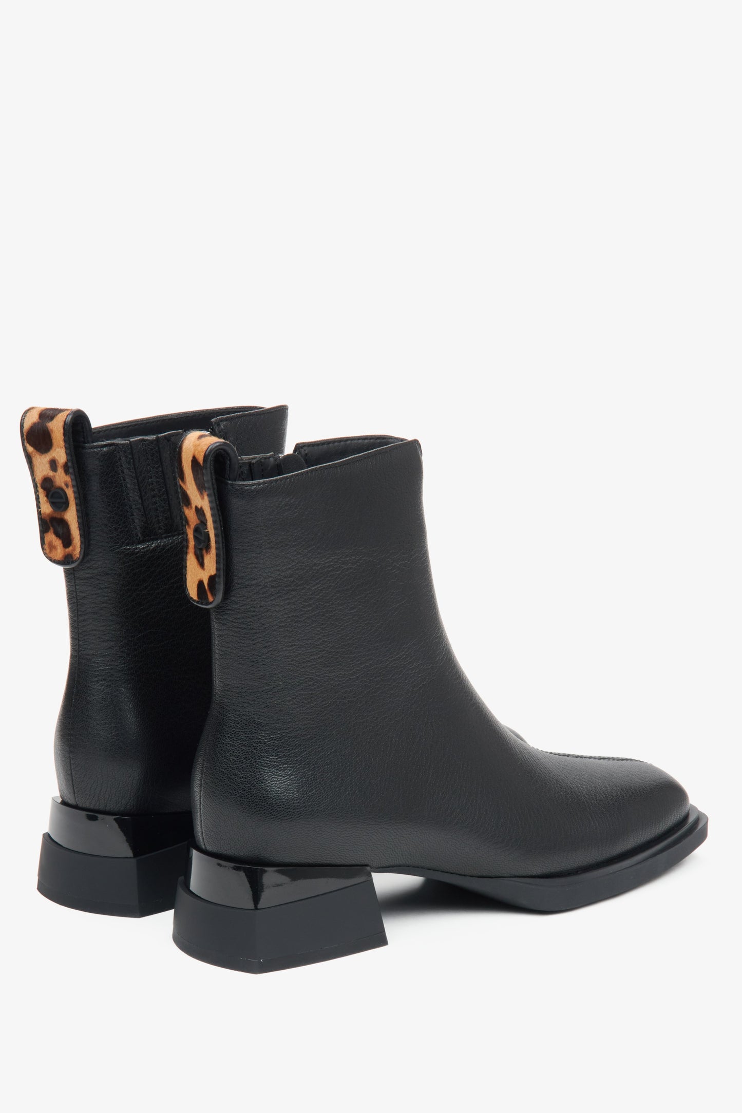 Schwarze Damen-Lederstiefeletten mit niedrigem Absatz und Tierdruck-Einsätzen – Nahaufnahme des Absatzes und der Seitenlinie der Schuhe.