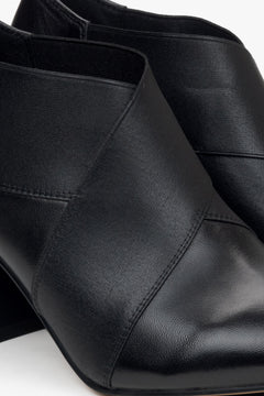 Niedrige schwarze Damen-Stiefeletten mit spitzer Kappe und stabilem Blockabsatz – Nahaufnahme der Details.