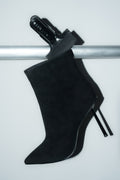 Inszenierte Darstellung der schwarzen Damen-Stiefelette aus Velours auf einer silbernen Stange 
