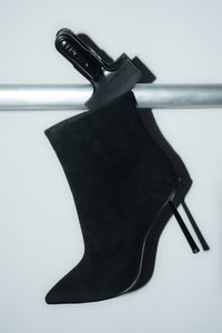 Inszenierte Darstellung der schwarzen Damen-Stiefelette aus Velours auf einer silbernen Stange 