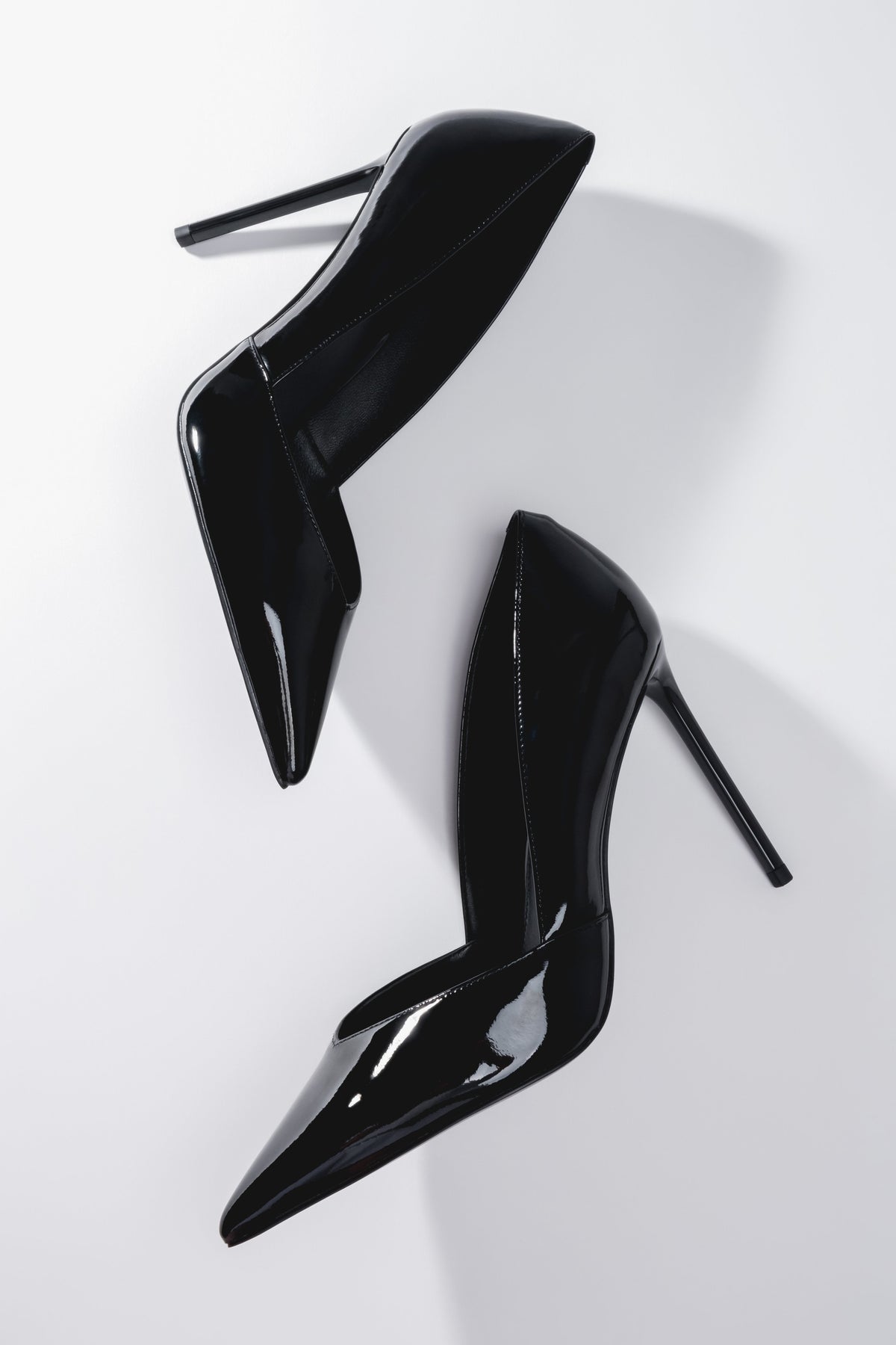 Künstlerische Draufsicht auf das Paar schwarzer Damen-Stilettos aus Lackleder