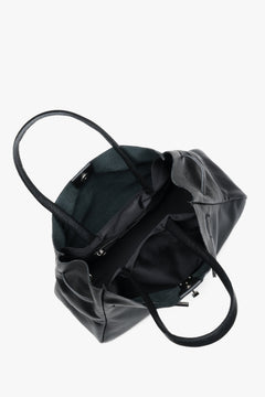 Blick von oben in die geöffnete schwarze Handtasche, die drei geräumige Fächer für A4-Dokumente zeigt 