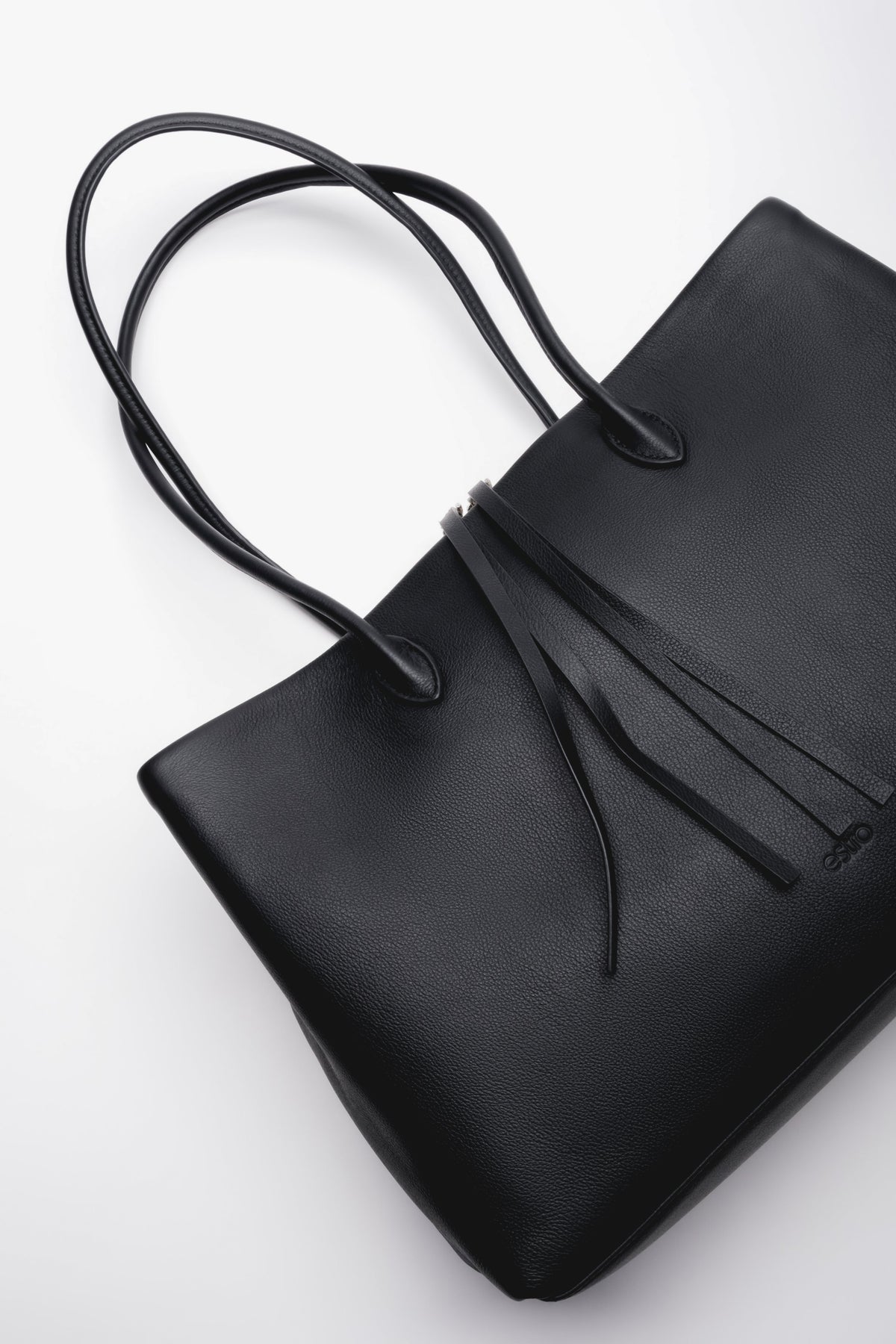 Schräge Draufsicht auf den Reißverschluss und die feinen Lederdetails der schwarzen Handtasche