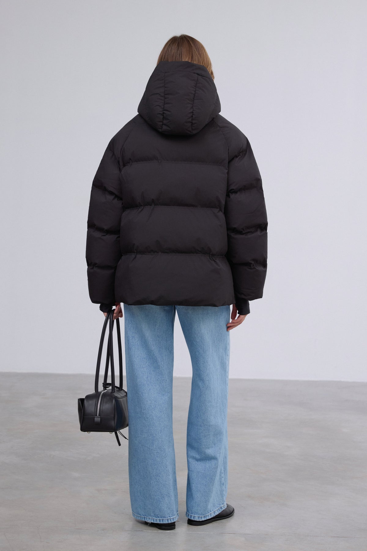 Rückansicht der schwarzen Damen-Daunenjacke mit Kapuze