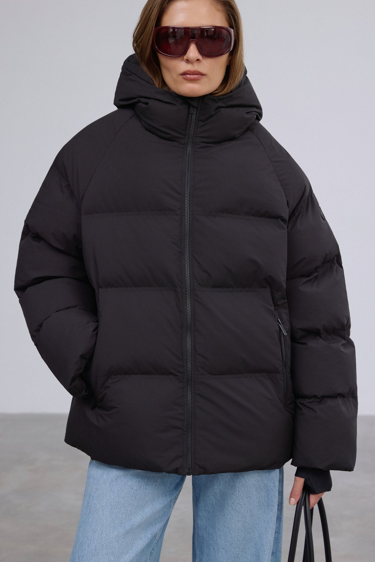 Frontale Silhouette in der geschlossenen schwarzen Winterjacke für Damen