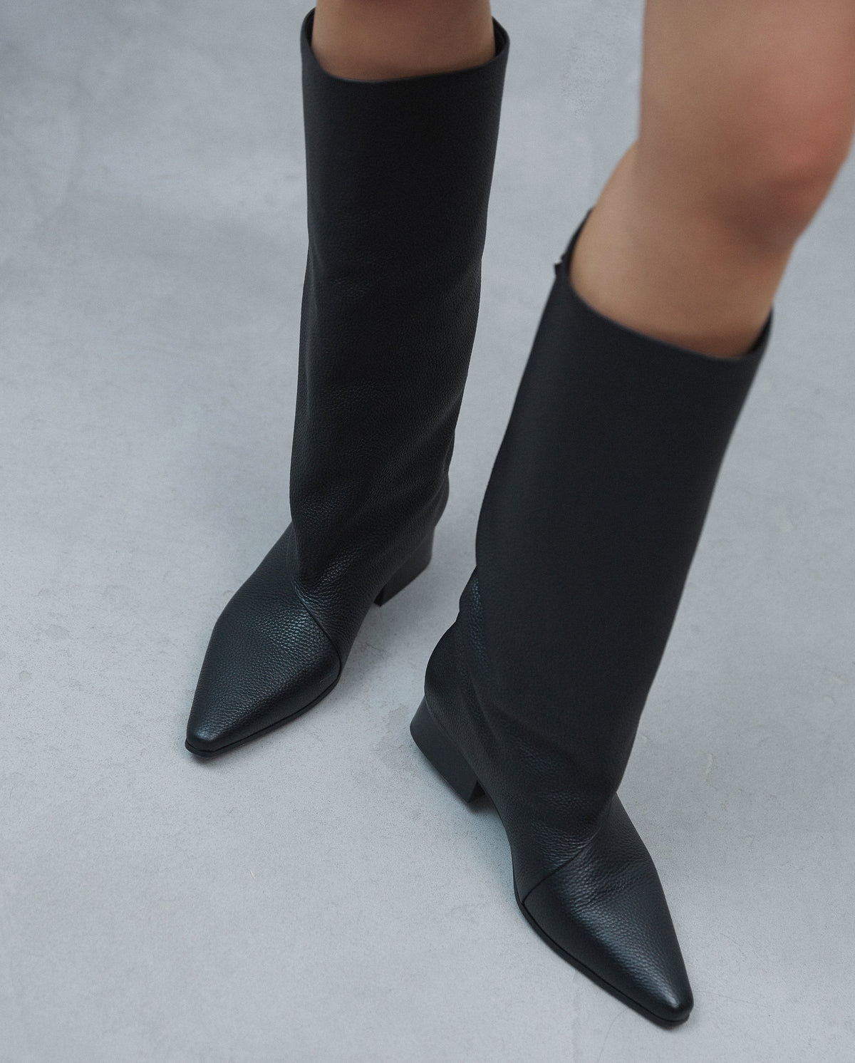 Detailansicht von oben auf die schwarzen Stiefel beim Gehen