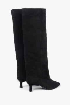 Schrägansicht von hinten, die den markanten 5,5-cm-Trichterabsatz der Veloursstiefel hervorhebt