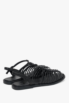 Rückansicht auf das Paar schwarzer Sandalen mit exklusiver Ledersohle.